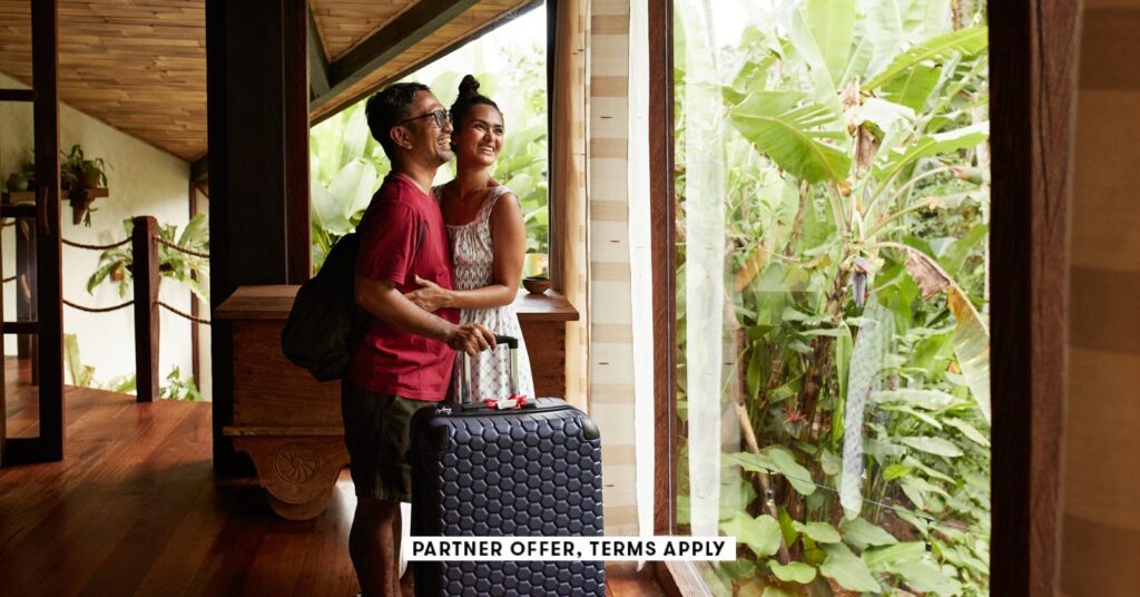 social image partner offer terms apply couple standing near window at villa with suitcase klaus vedf.jpeg