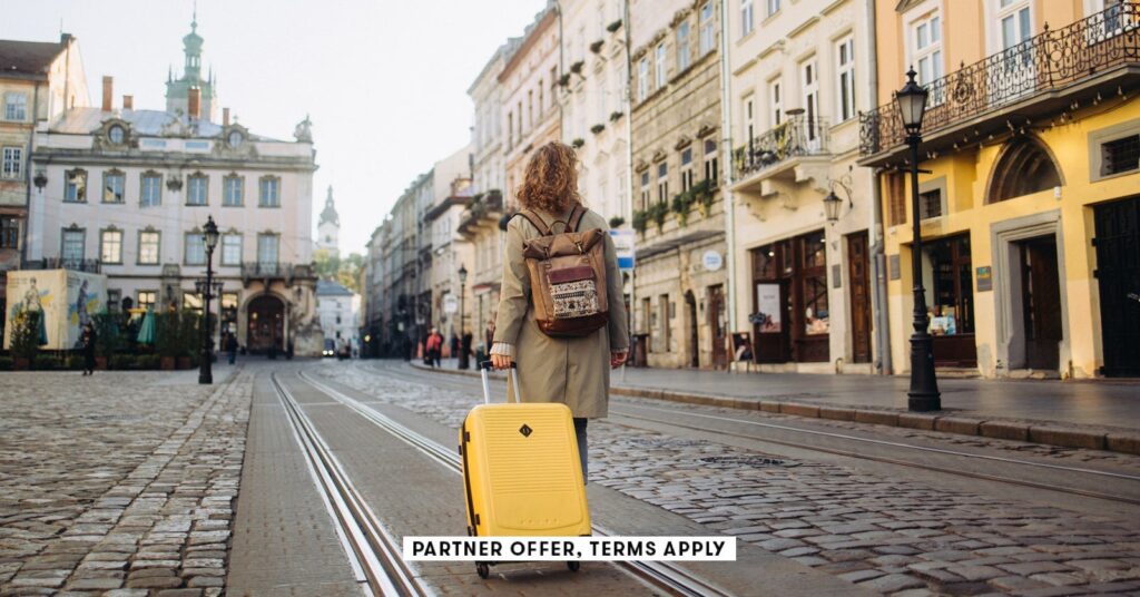 Atmos Summit card: Maximize rewards for global vacationers social image partner offer terms apply woman with a suitcase walking on european street nazar rybak.jpeg