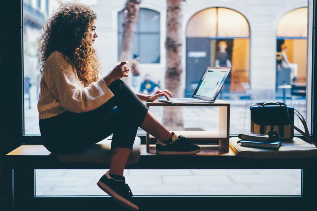 female student siting on bench checking account online browsing scaled.webp.webp