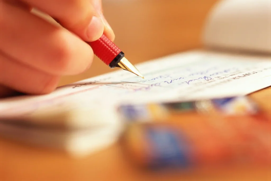 16 Highest Checking Accounts of June 2026 womans hand writing check scaled.webp.webp