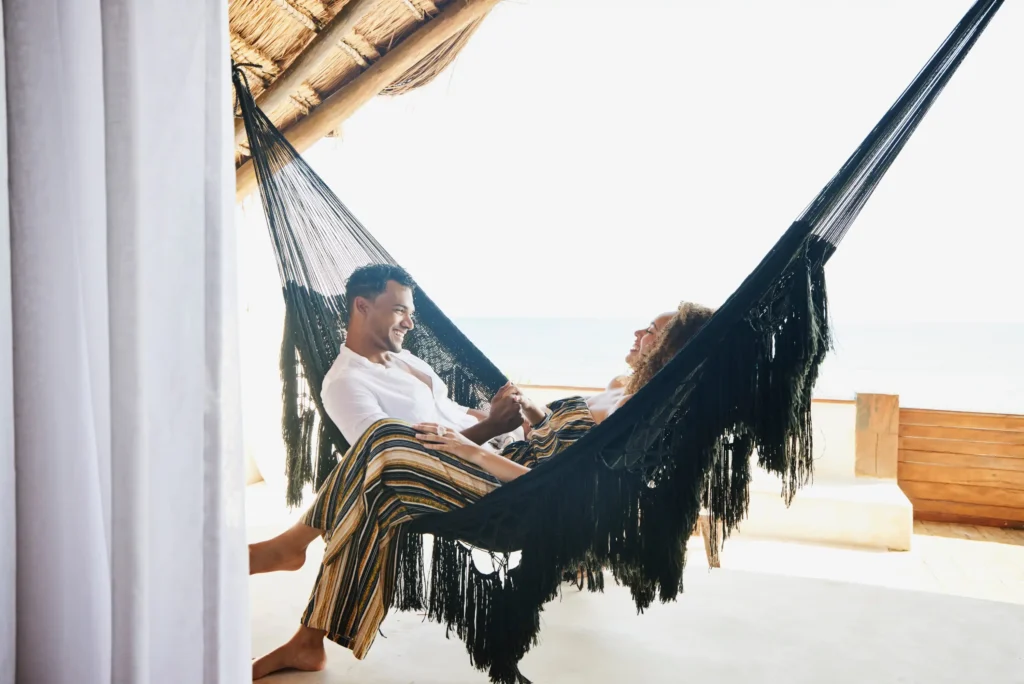 young couple holding hands sitting hammock.webp.webp